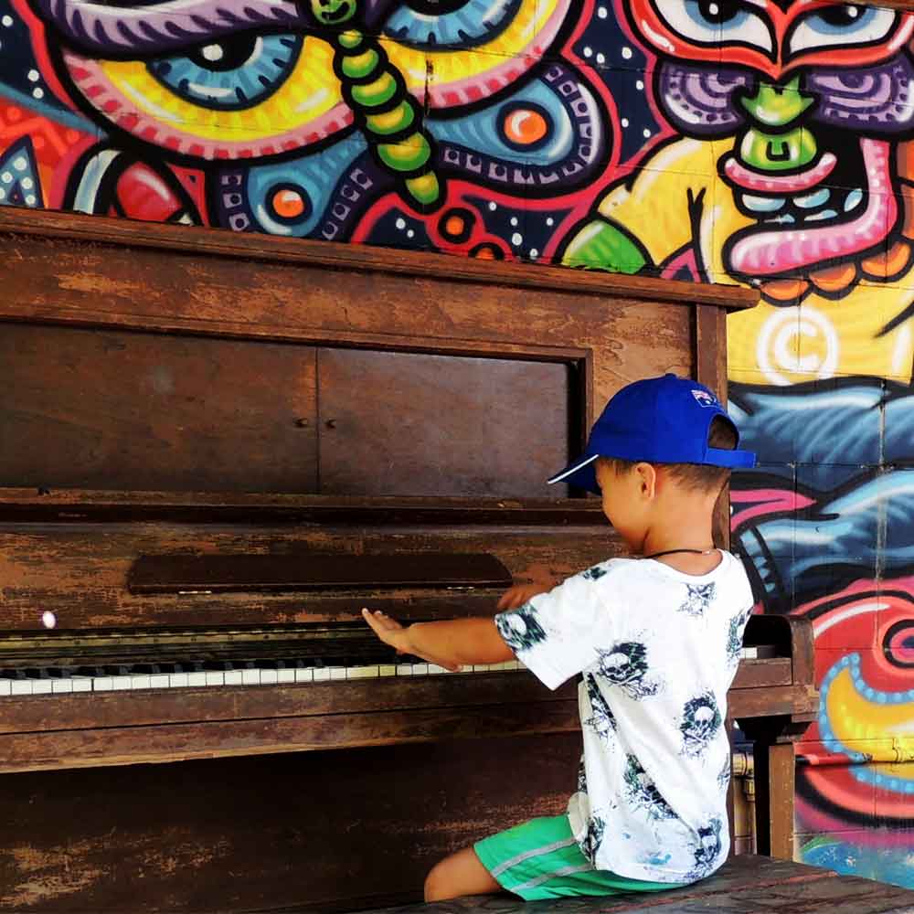 Little boy playing piano outside