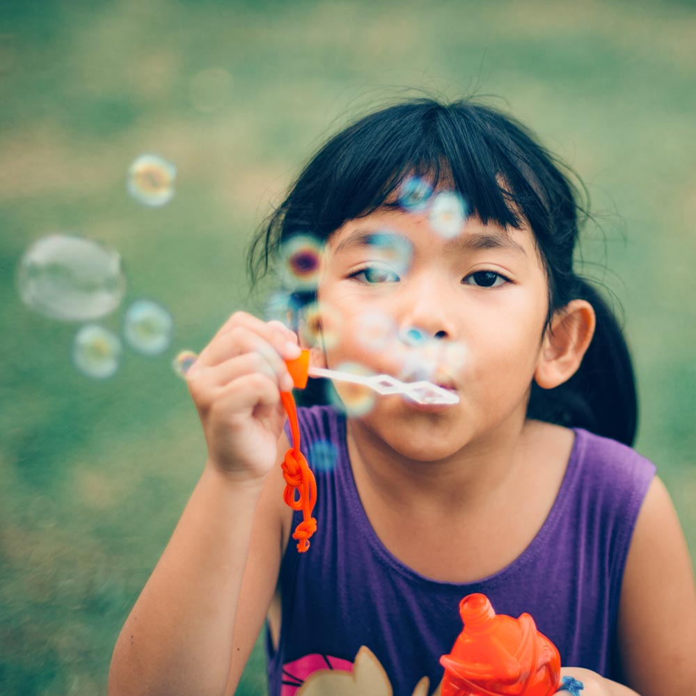 Asian girl blowing bubbles