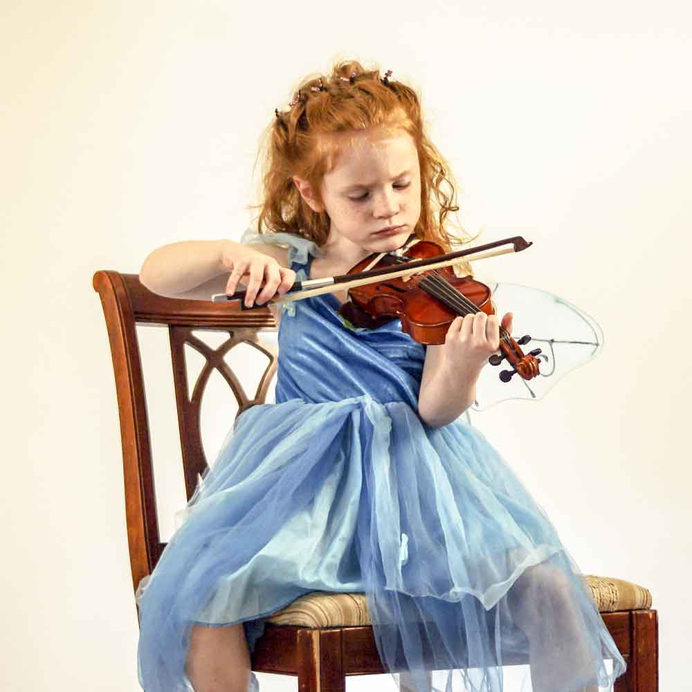 Little girl playing violin in dress