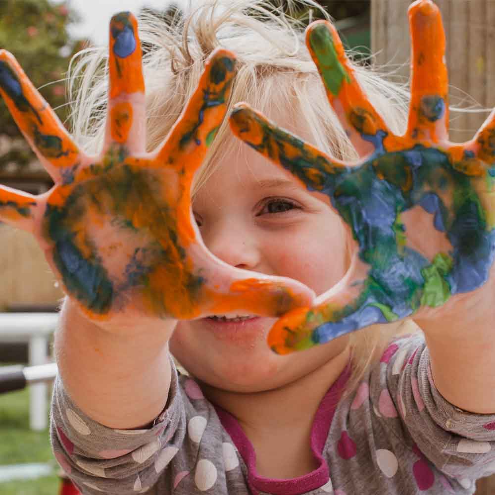 Child with colourful paint on hands