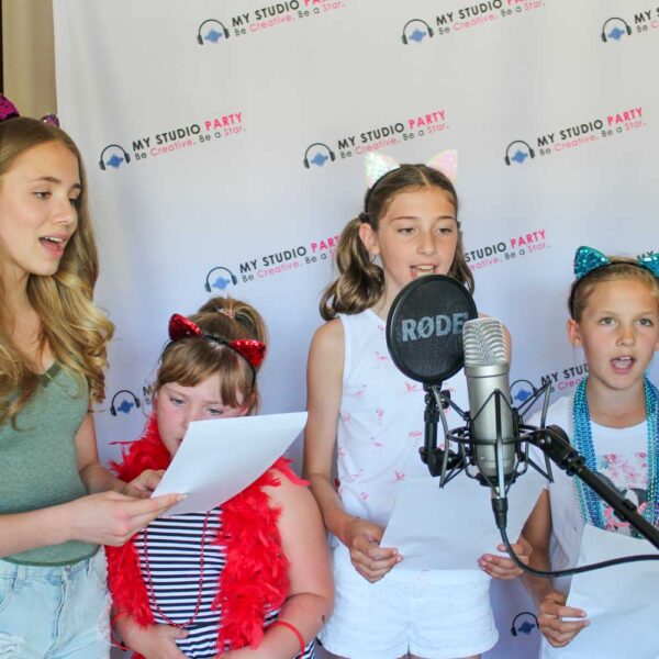 Kids singing into a microphone with My Studio Party