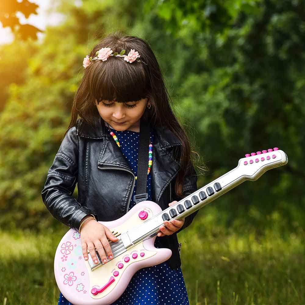 Little girl with leather jacket playing pink guitar