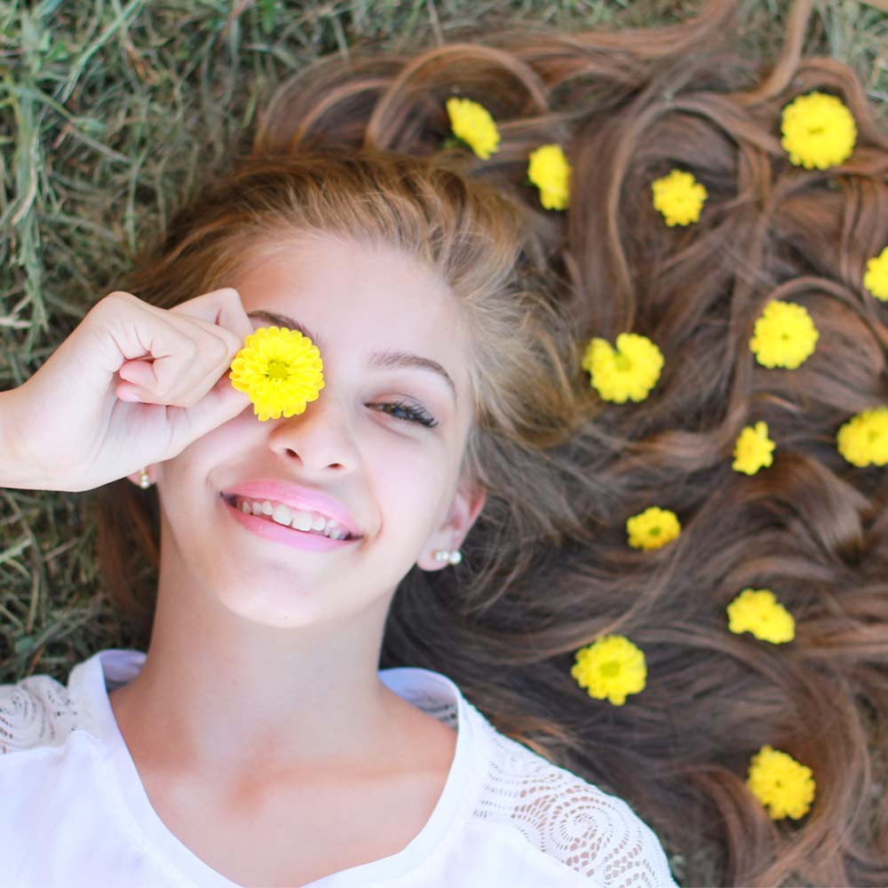 Girl on grass with dandelions in hair