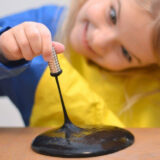 black magnetic slime stretched with a magnet