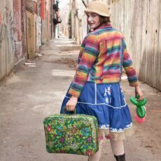 girl clown with colorful suitcase