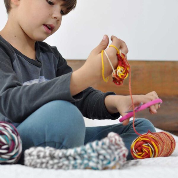 boy-sitting-on-bed-finger-knitting