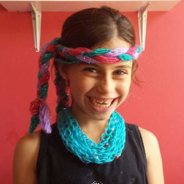 young girl with head band and blue finger knitted scarf